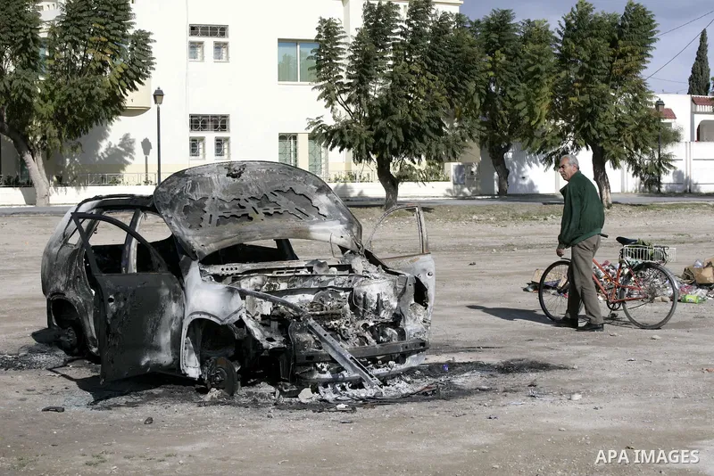 Burned cars are seen on a street in Carthage, outside Tunis, January 22, 2011.A Tunisian prosecutor opened an investigation into the overseas assets of the ousted president and his deeply resented family Wednesday, as th...