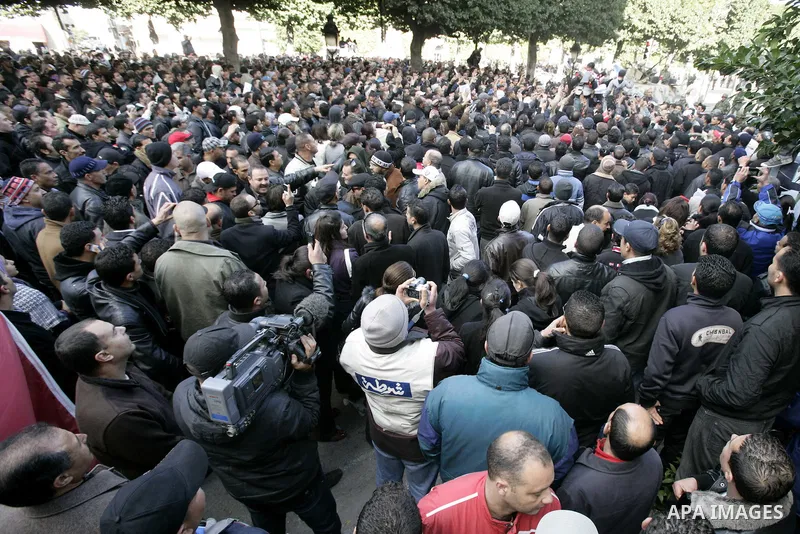 Tunisians, amongst them policemen, gather to ask for the right to form unions and better salaries as the vehicle of Tunisian interim President Fouad Mbazaa (not in picture) arrives at the government Palace in Tunis, Tuni...