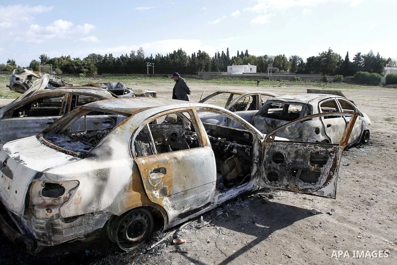 Burned cars are seen on a street in Carthage, outside Tunis, January 22, 2011.A Tunisian prosecutor opened an investigation into the overseas assets of the ousted president and his deeply resented family Wednesday, as th...