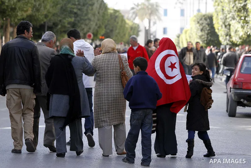 Tunisians, amongst them policemen, gather to ask for the right to form unions and better salaries as the vehicle of Tunisian interim President Fouad Mbazaa (not in picture) arrives at the government Palace in Tunis, Tuni...