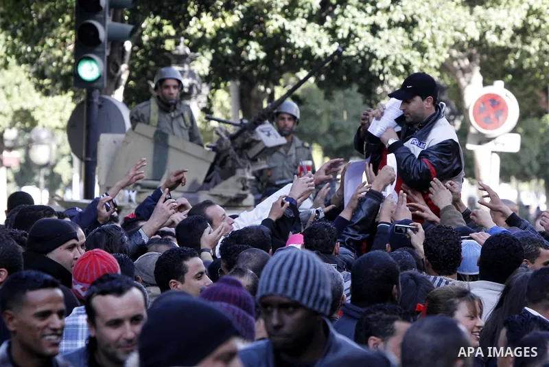 Tunisians, amongst them policemen, gather to ask for the right to form unions and better salaries as the vehicle of Tunisian interim President Fouad Mbazaa (not in picture) arrives at the government Palace in Tunis, Tuni...