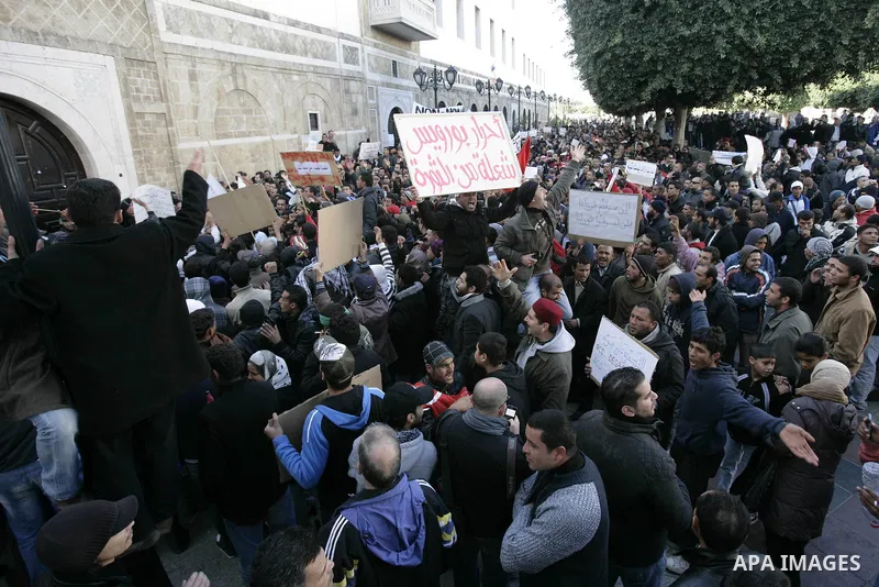 Tunisians hold placards during a demonstration to demand a new government free of officials of the ousted regime of former president Zine el Abidine Ben Ali, goes on in central Tunis, Tunisia, 23 January 2011. According...