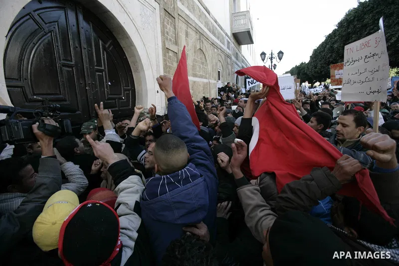 Tunisian protestors prepare to break into the barbed wire during a demonstration to demand a new government free of officials of the ousted regime of former president Zine el Abidine Ben Ali, in central Tunis, Tunisia, 2...