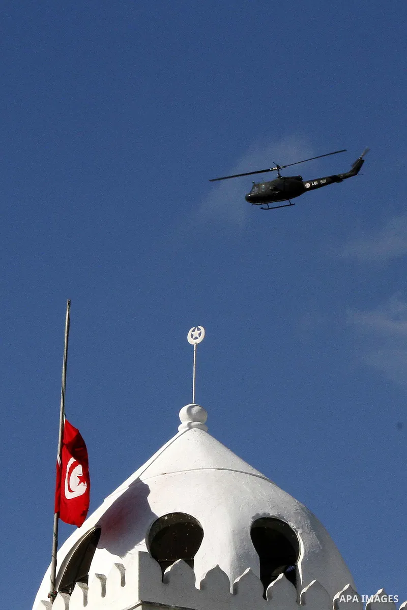 A military helicopter is seen as Tunisians take part a demonstration to demand a new government free of officials of the ousted regime of former president Zine el Abidine Ben Ali, goes on in central Tunis, Tunisia, 23 Ja...