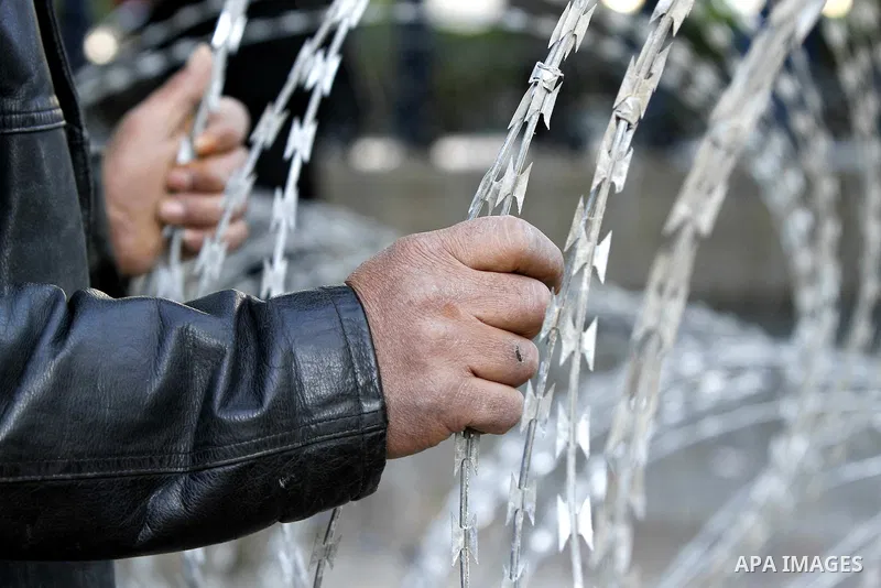 Tunisian protestors prepare to break into the barbed wire during a demonstration to demand a new government free of officials of the ousted regime of former president Zine el Abidine Ben Ali, in central Tunis, Tunisia, 2...