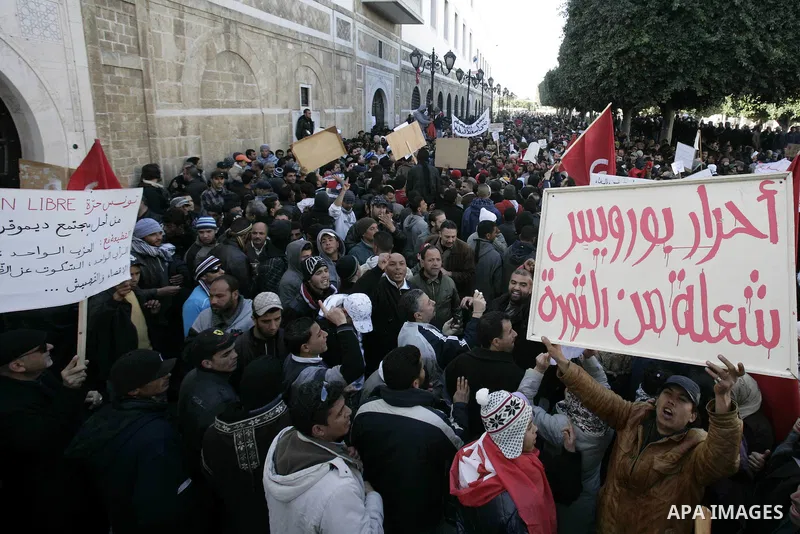 Tunisians hold placards during a demonstration to demand a new government free of officials of the ousted regime of former president Zine el Abidine Ben Ali, goes on in central Tunis, Tunisia, 23 January 2011. According...