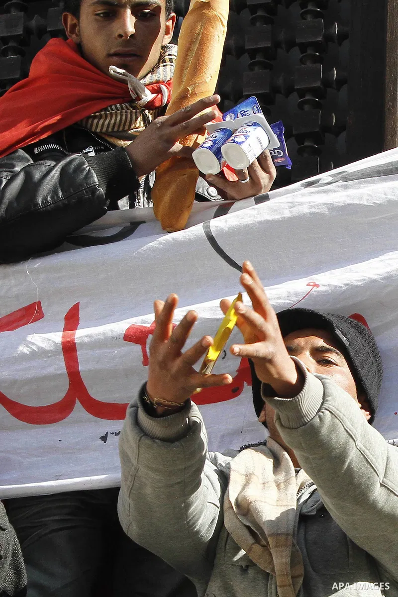 A Tunisian man holds bread during a demonstration to demand a new government free of officials of the ousted regime of former president Zine el Abidine Ben Ali, goes on in central Tunis, Tunisia, 23 January 2011. Accordi...