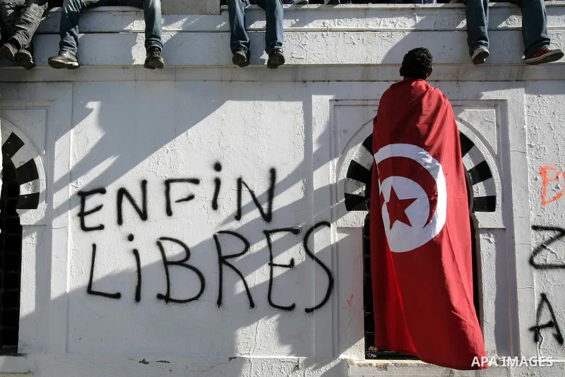 Tunisians hold placards during a demonstration to demand a new government free of officials of the ousted regime of former president Zine el Abidine Ben Ali, goes on in central Tunis, Tunisia, 23 January 2011. According...