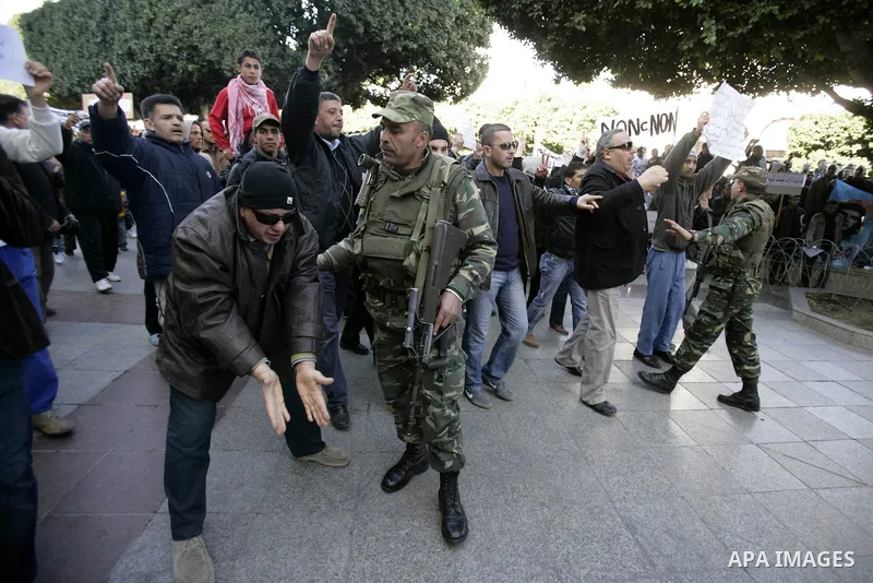 Tunisians hold placards during a demonstration to demand a new government free of officials of the ousted regime of former president Zine el Abidine Ben Ali, goes on in central Tunis, Tunisia, 23 January 2011. According...