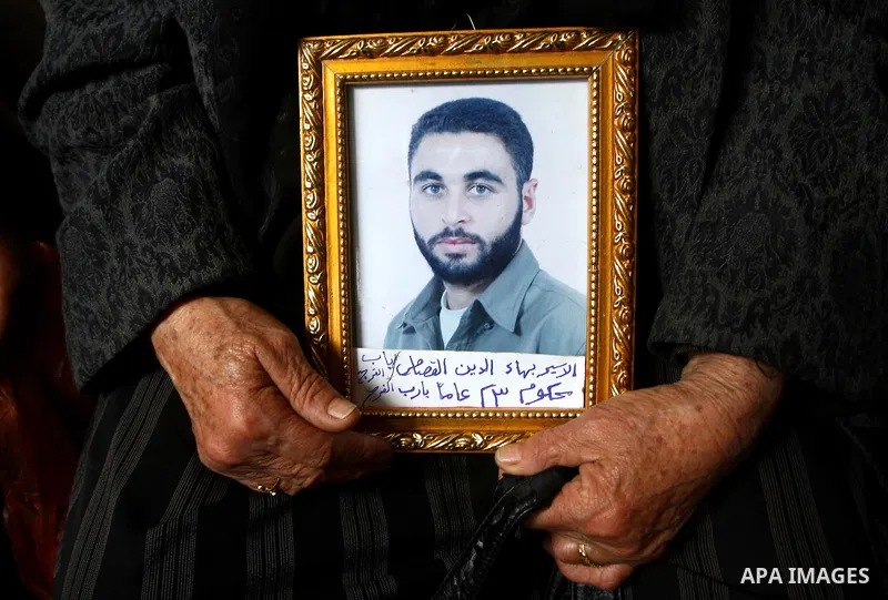 A Palestinian woman holds a picture of jailed relative during a protest calling for the release of Palestinian prisoners from Israeli jails at the Red Cross office in Gaza City on Jan. 24, 2011. Photo by Ashraf Amra