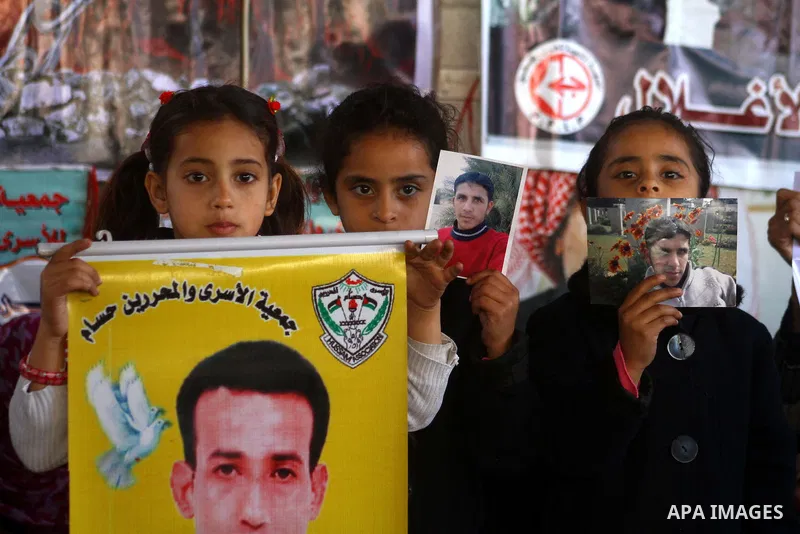 Palestinian women and children hold pictures of jailed relatives during a protest calling for the release of Palestinian prisoners from Israeli jails at the Red Cross office in Gaza City on Jan. 24, 2011. Photo by Ashraf...