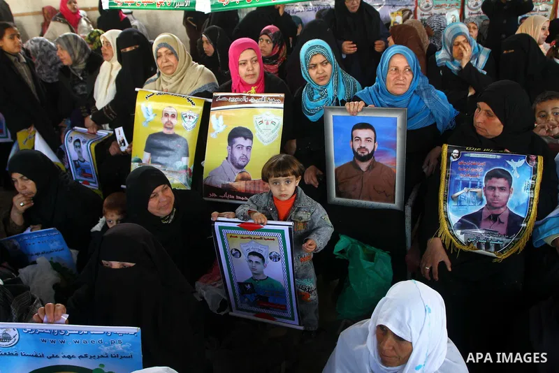 Palestinian women and children hold pictures of jailed relatives during a protest calling for the release of Palestinian prisoners from Israeli jails at the Red Cross office in Gaza City on Jan. 24, 2011. Photo by Ashraf...