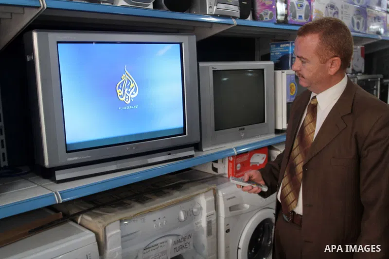 A Palestinian man watchs Al-Jazeera channel at his shop, in Gaza City on Jan. 24, 2011. Al-Jazeera yesterday, revealed leaked documents recorded during the negotiations that occur between the Palestinian Authority and th...