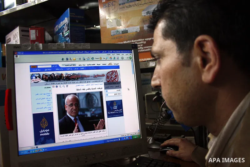 A Palestinian man go on the internet in his shop in the West Bank city of Hebron on 24 January 2011 concerning the 1,600 secret documents published by Al-Jazeera about the Israeli Palestinian negotiations. Palestinian of...