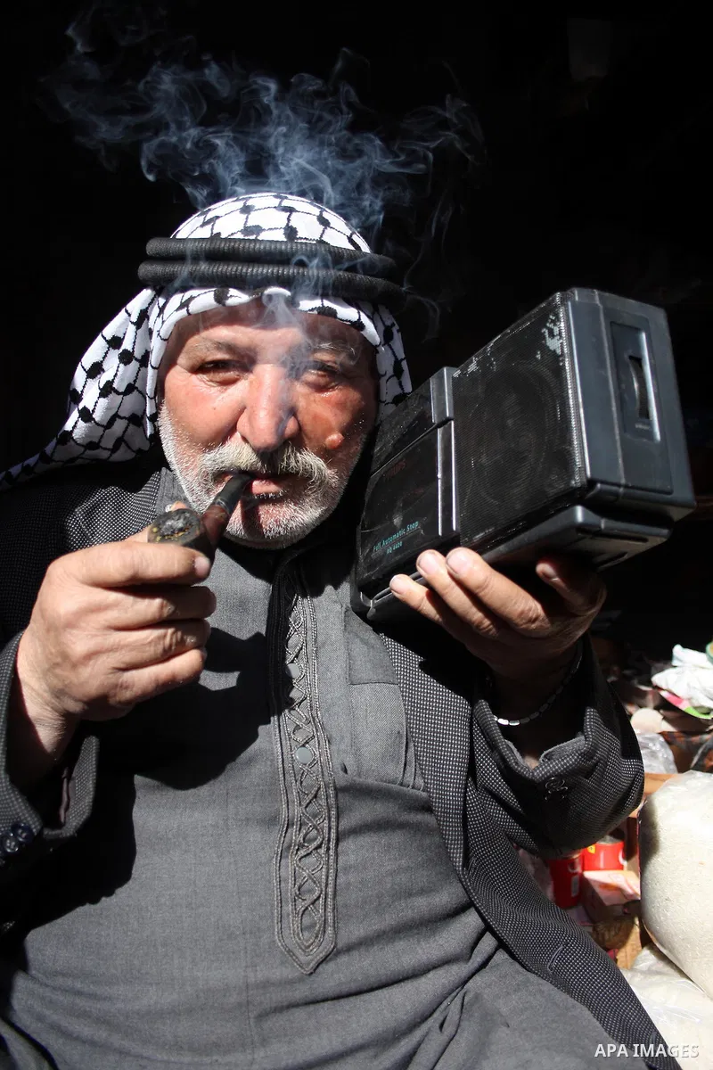 A Palestinian man listens to the Radio in front of his shop in the West Bank city of Hebron on 24 January 2011 concerning the 1,600 secret documents published by Al-Jazeera about the Israeli Palestinian negotiations. Pal...