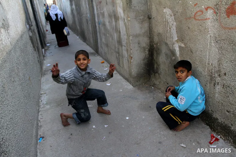 Palestinian refugee children play in front of their home in the Jabalia refugee camp in the northern Gaza Strip on January 24, 2011 a day after leaked documents were published by Al-Jazeera and the British newspaper the...