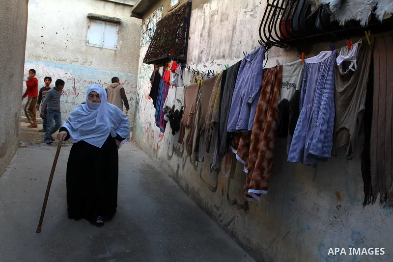 Palestinian refugees walk in front of their home in the Jabalia refugee camp in the northern Gaza Strip on January 24, 2011 a day after leaked documents were published by Al-Jazeera and the British newspaper the Guardian...