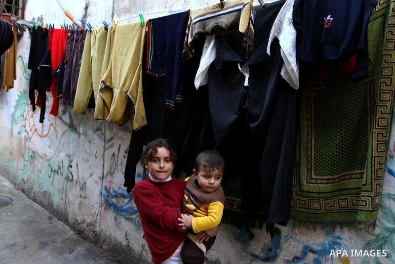 Palestinian refugee children stand in front of their home in the Jabalia refugee camp in the northern Gaza Strip on January 24, 2011 a day after leaked documents were published by Al-Jazeera and the British newspaper the...