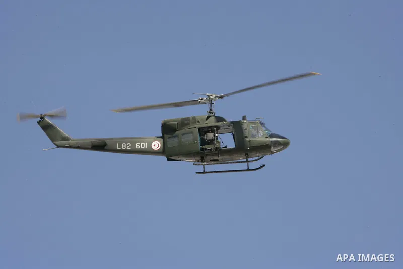 A military helicopter is seen as Tunisian protesters gather to demand a new government free of officials of the ousted regime of former president Zine el Abidine Ben Ali, near the Prime Minister's office in Tunis, Tunisi...