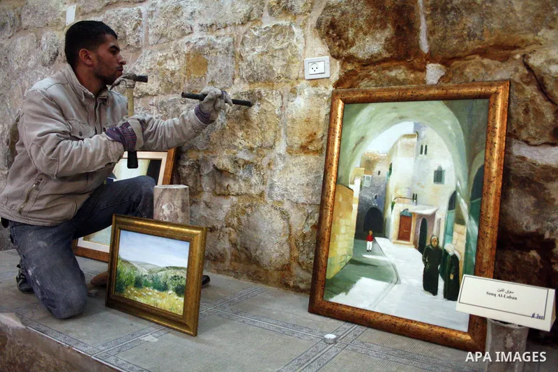 A Palestinian laborer works near a callgraphic works during the opening of the ( Old City Museum ) in the old city of the West Bank city of Hebron on January 25, 2011. The museum located in " Haret Dari " near the Khan a...