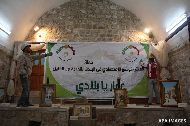 Palestinian laborers work near a callgraphic works during the opening of the ( Old City Museum ) in the old city of the West Bank city of Hebron on January 25, 2011. The museum located in " Haret Dari " near the Khan al-...