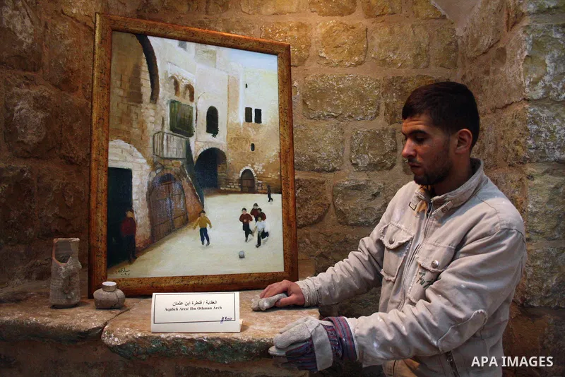 A Palestinian laborer works near a callgraphic works during the opening of the ( Old City Museum ) in the old city of the West Bank city of Hebron on January 25, 2011. The museum located in " Haret Dari " near the Khan a...