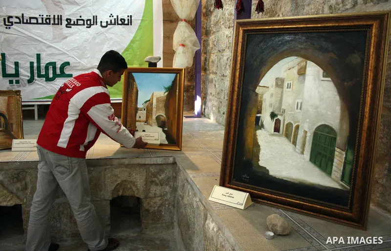 A Palestinian laborer works near a callgraphic works during the opening of the ( Old City Museum ) in the old city of the West Bank city of Hebron on January 25, 2011. The museum located in " Haret Dari " near the Khan a...