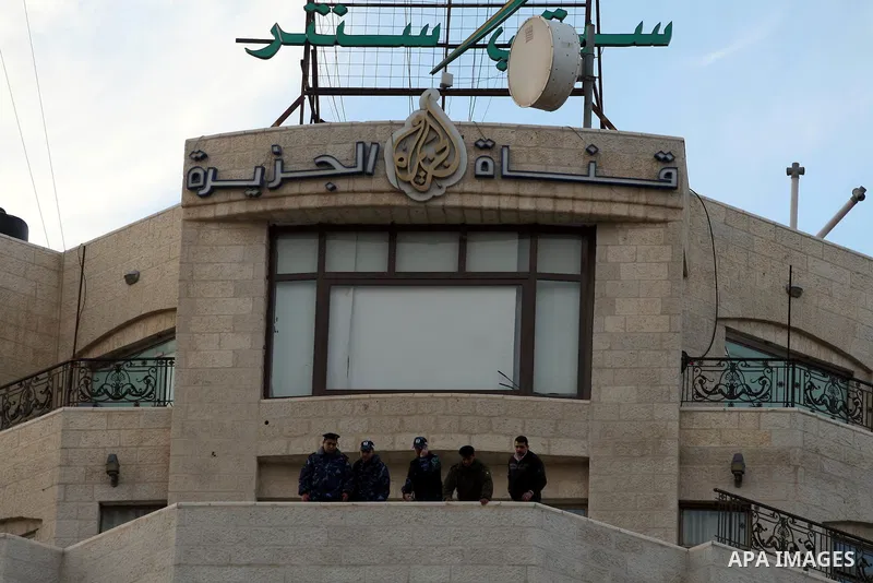 Palestinian security forces stand guard as supporters of the President Mahmoud Abbas gather next to Al-Jazeera office in the West Bank town of Ramallah, to protest against Al-Jazeera TV Channel on 25 January 2011. Palest...