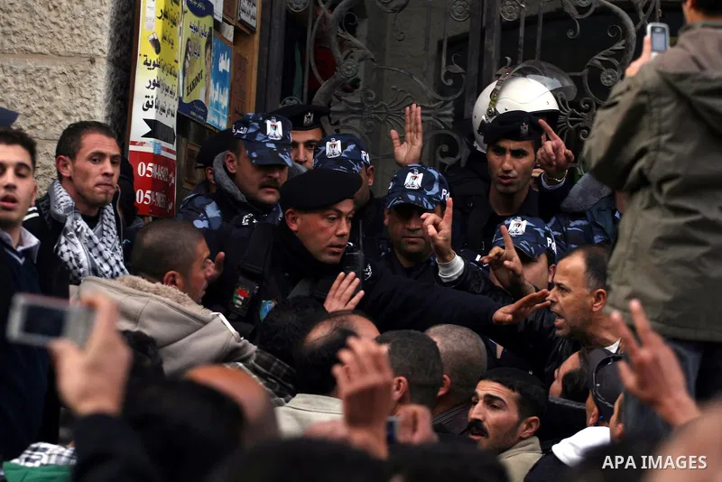 Palestinians supporters of the President Mahmoud Abbas gather next to Al-Jazeera office in the West Bank town of Ramallah, to protest against Al-Jazeera TV Channel on 25 January 2011. Palestinian negotiators privately ag...