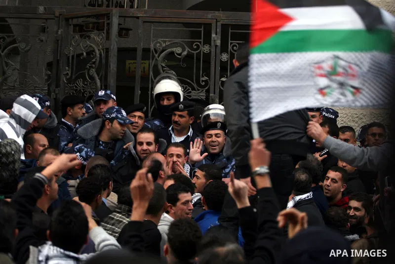 Palestinians supporters of the President Mahmoud Abbas gather next to Al-Jazeera office in the West Bank town of Ramallah, to protest against Al-Jazeera TV Channel on 25 January 2011. Palestinian negotiators privately ag...