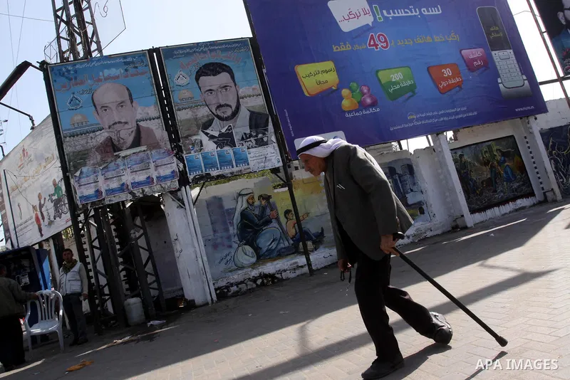 A Palestinian man walks past posters depicting the leaders of Al-Aqsa Martyrs Brigades, Jihad Al-Ammarin and Wail Al-Nimra, in Gaza City on Jan. 26,2011. Palestinian factions accused the Palestinian Authority in the West...