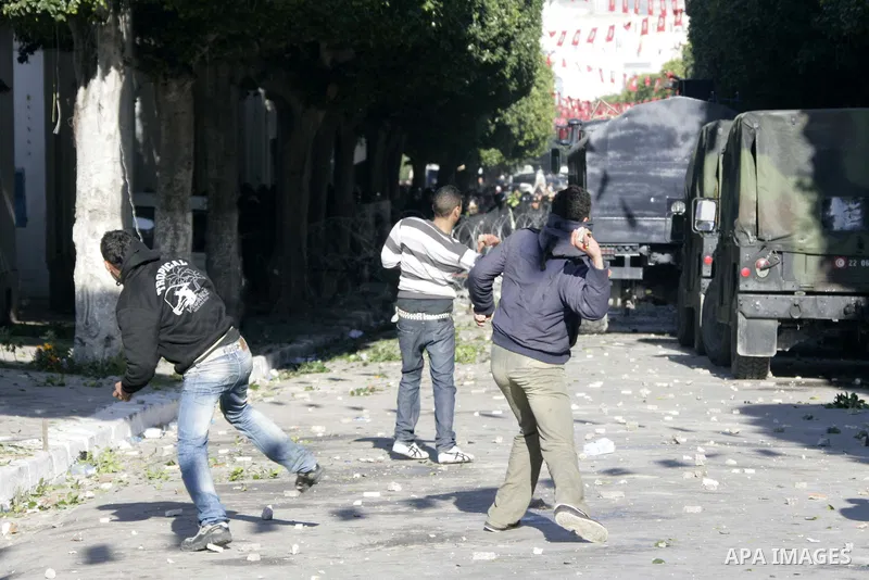 Tunisian youths hurl stones towards policemen during a demonstration against Prime Minister Mohammed Ghannouchi in front of the government palace in Tunis.Tunisia, 26 January 2011, Hundreds of defiant Tunisians camped in...