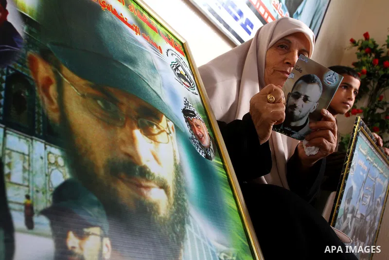 The mother of senior Fatah military commander Hassan al-Madhoun holds a picture of her son inside his family's house in Jabalya in the northern Gaza Strip Jan. 26, 2011. Thousands of protestors marched in Jabalya refugee...