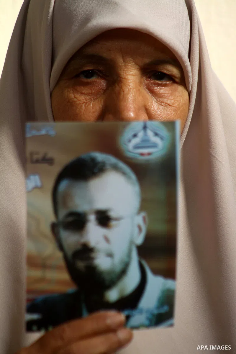 The mother of senior Fatah military commander Hassan al-Madhoun holds a picture of her son inside his family's house in Jabalya in the northern Gaza Strip Jan. 26, 2011. Thousands of protestors marched in Jabalya refugee...