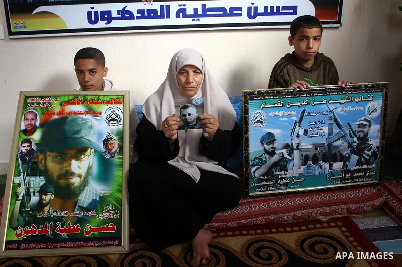 The mother of senior Fatah military commander Hassan al-Madhoun holds a picture of her son inside his family's house in Jabalya in the northern Gaza Strip Jan. 26, 2011. Thousands of protestors marched in Jabalya refugee...