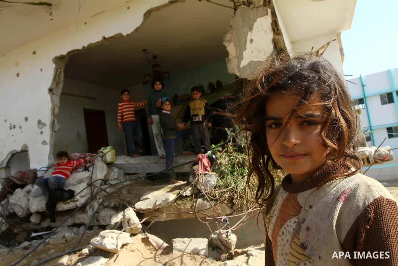 Palestinian children play outside their home which were partially destroyed during the Israeli war on Gaza in Jabalya in the northern Gaza Strip Jan. 26, 2011. a day after leaked documents were published by Al-Jazeera, s...