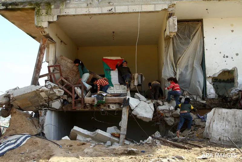 Palestinian children play outside their home which were partially destroyed during the Israeli war on Gaza in Jabalya in the northern Gaza Strip Jan. 26, 2011. a day after leaked documents were published by Al-Jazeera, s...