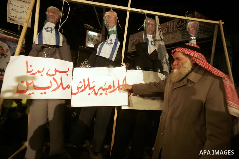 Palestinian Hamas activists take part rally against Abbas, following a recent broadcast by Al-Jazeera reportedly linking him to making broad concessions to Israel in peace talks, in Rafah, southern Gaza Strip, Wednesday,...