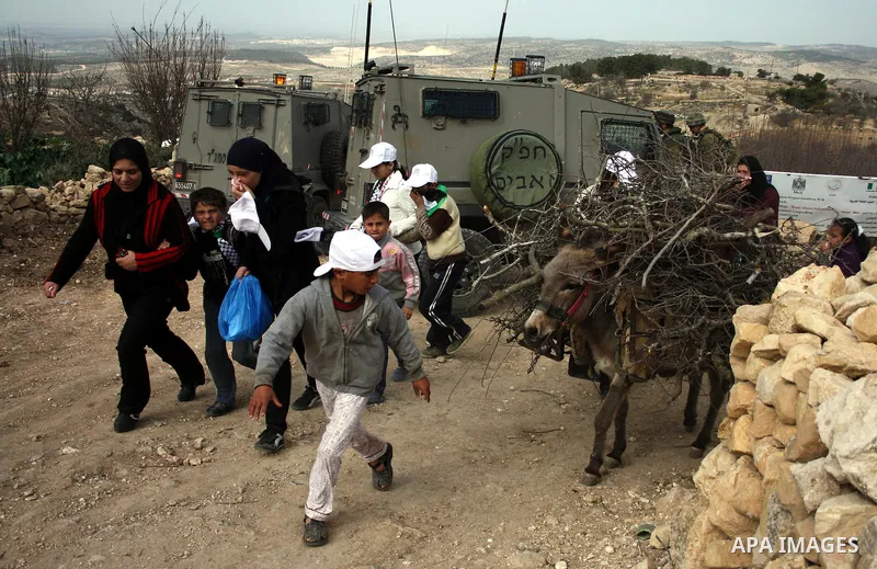 Israeli soldiers stand guard during a demonstration by Palestinian, Israeli and foreign activists against the demolishing of farm land to be used in the construction of Jewish settlements near the existing Israeli settle...