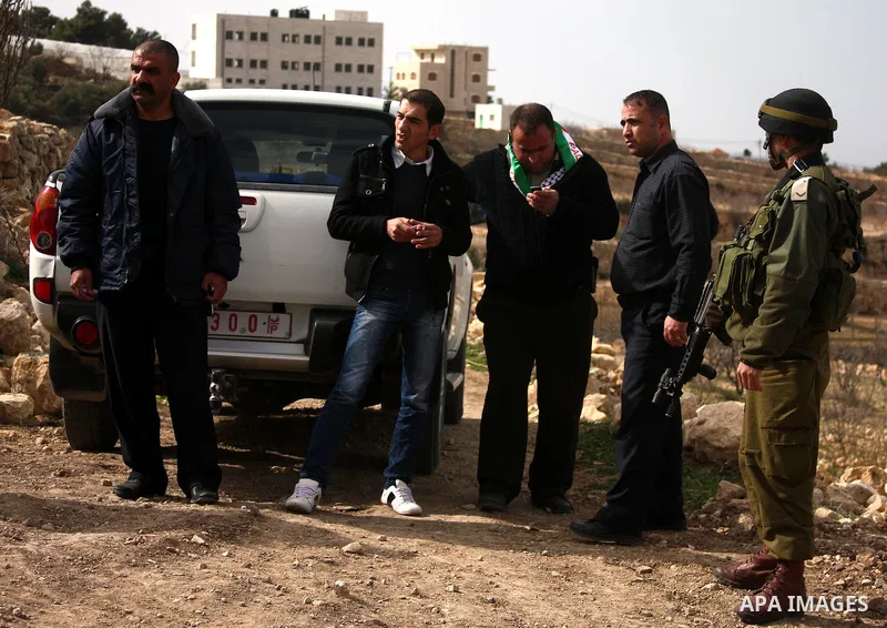 Israeli soldiers stand guard during a demonstration by Palestinian, Israeli and foreign activists against the demolishing of farm land to be used in the construction of Jewish settlements near the existing Israeli settle...