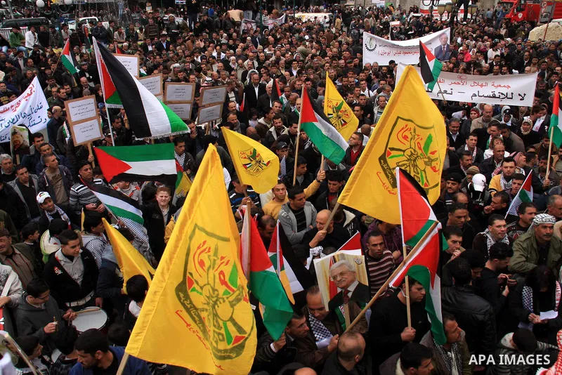 Palestinians hold Fatah flags and national flags during a rally in the West Bank City of Nablus , to protest against Al-Jazeera TV Channel on 27 January 2011. Al-Jazeera, a Qatar-based Arab satellite station, this week p...