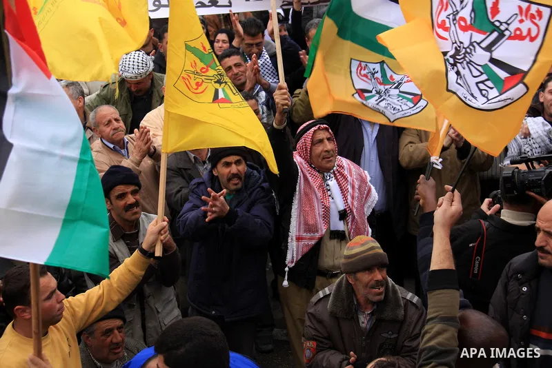 Palestinians hold Fatah flags and national flags during a rally in the West Bank City of Nablus , to protest against Al-Jazeera TV Channel on 27 January 2011. Al-Jazeera, a Qatar-based Arab satellite station, this week p...