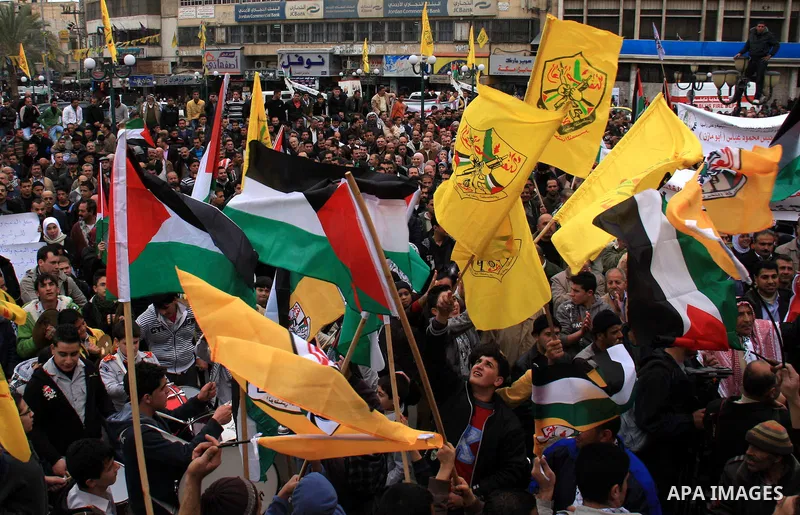 Palestinians hold Fatah flags and national flags during a rally in the West Bank City of Nablus , to protest against Al-Jazeera TV Channel on 27 January 2011. Al-Jazeera, a Qatar-based Arab satellite station, this week p...