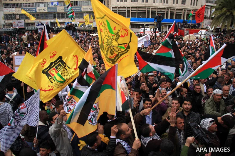 Palestinians hold Fatah flags and national flags during a rally in the West Bank City of Nablus , to protest against Al-Jazeera TV Channel on 27 January 2011. Al-Jazeera, a Qatar-based Arab satellite station, this week p...
