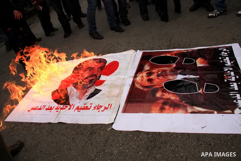 Palestinian Fatah activists burn posters of Palestinian Hamas leaders Khaled Meshaal and Mahmoud Zahar covered by printed footsteps during a rally in the West Bank City of Nablus , to protest against Al-Jazeera TV Channe...
