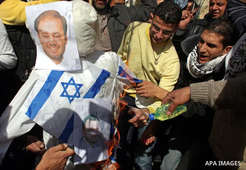 Palestinian Fatah supporters hold flags and signs during a rally supporting Palestinian President Mahmoud Abbas, and against Al-Jazeera, in the West Bank town of Hebron, Friday, Jan. 28, 2011. Al-Jazeera, a Qatar-based A...