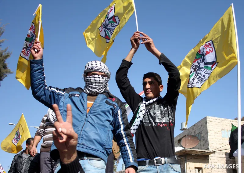 Palestinian Fatah supporters hold flags and signs during a rally supporting Palestinian President Mahmoud Abbas, and against Al-Jazeera, in the West Bank town of Hebron, Friday, Jan. 28, 2011. Al-Jazeera, a Qatar-based A...