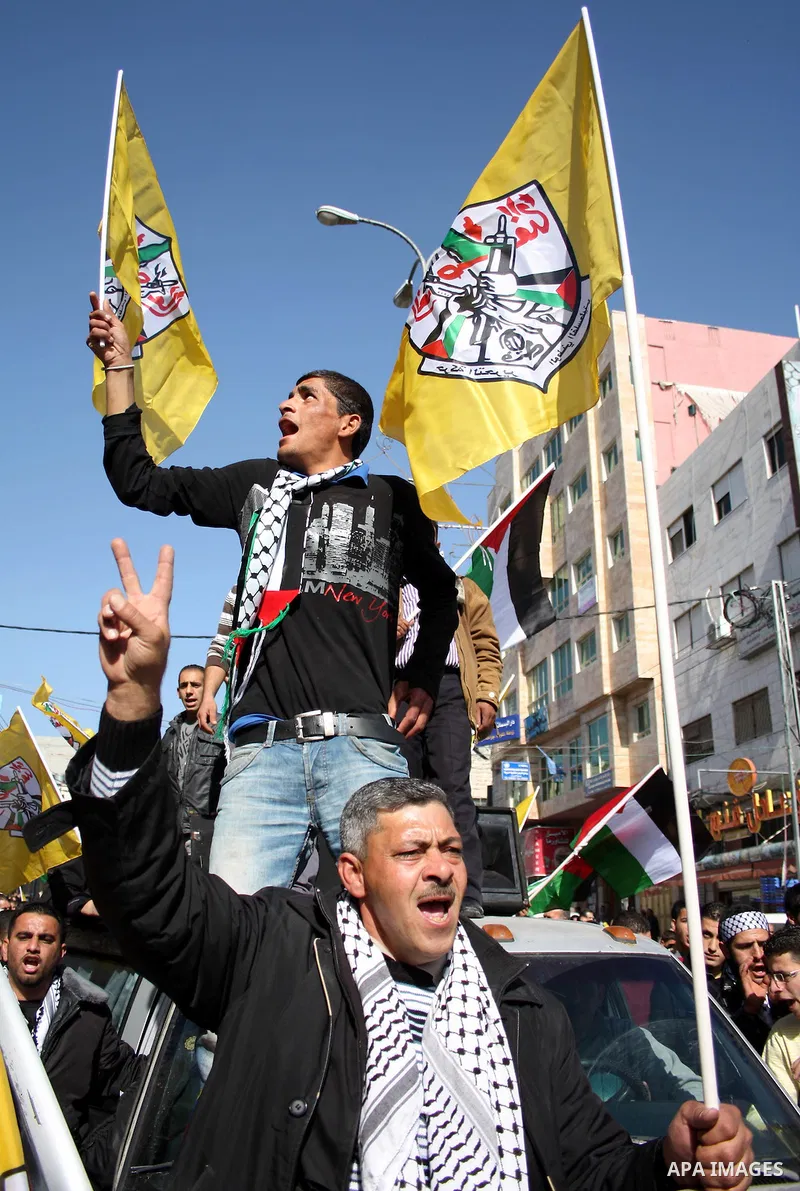 Palestinian Fatah supporters hold flags and signs during a rally supporting Palestinian President Mahmoud Abbas, and against Al-Jazeera, in the West Bank town of Hebron, Friday, Jan. 28, 2011. Al-Jazeera, a Qatar-based A...