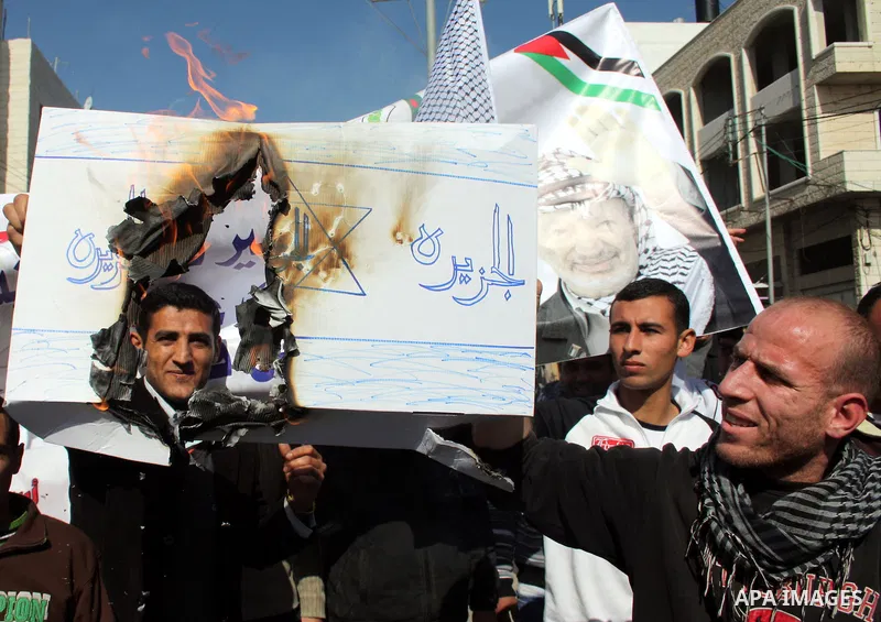 Palestinian Fatah supporters hold flags and signs during a rally supporting Palestinian President Mahmoud Abbas, and against Al-Jazeera, in the West Bank town of Hebron, Friday, Jan. 28, 2011. Al-Jazeera, a Qatar-based A...
