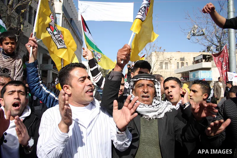 Palestinian Fatah supporters hold flags and signs during a rally supporting Palestinian President Mahmoud Abbas, and against Al-Jazeera, in the West Bank town of Hebron, Friday, Jan. 28, 2011. Al-Jazeera, a Qatar-based A...